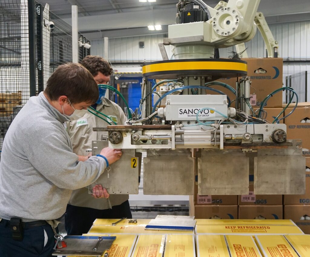 Maintenance Technicians changing panels on a Sanovo Palletizer